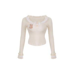 White long-sleeve top with teddy bear design on a white background