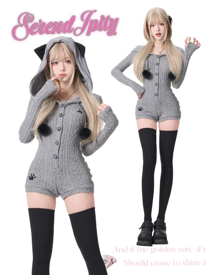 Person wearing a gray cat-themed outfit with a hood and black paws, standing against a white background.