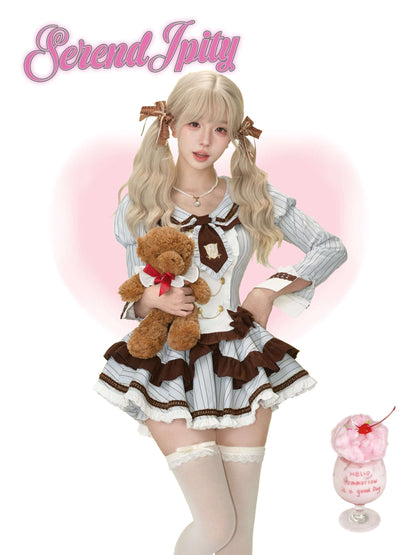 Person in a blue and brown outfit holding a teddy bear