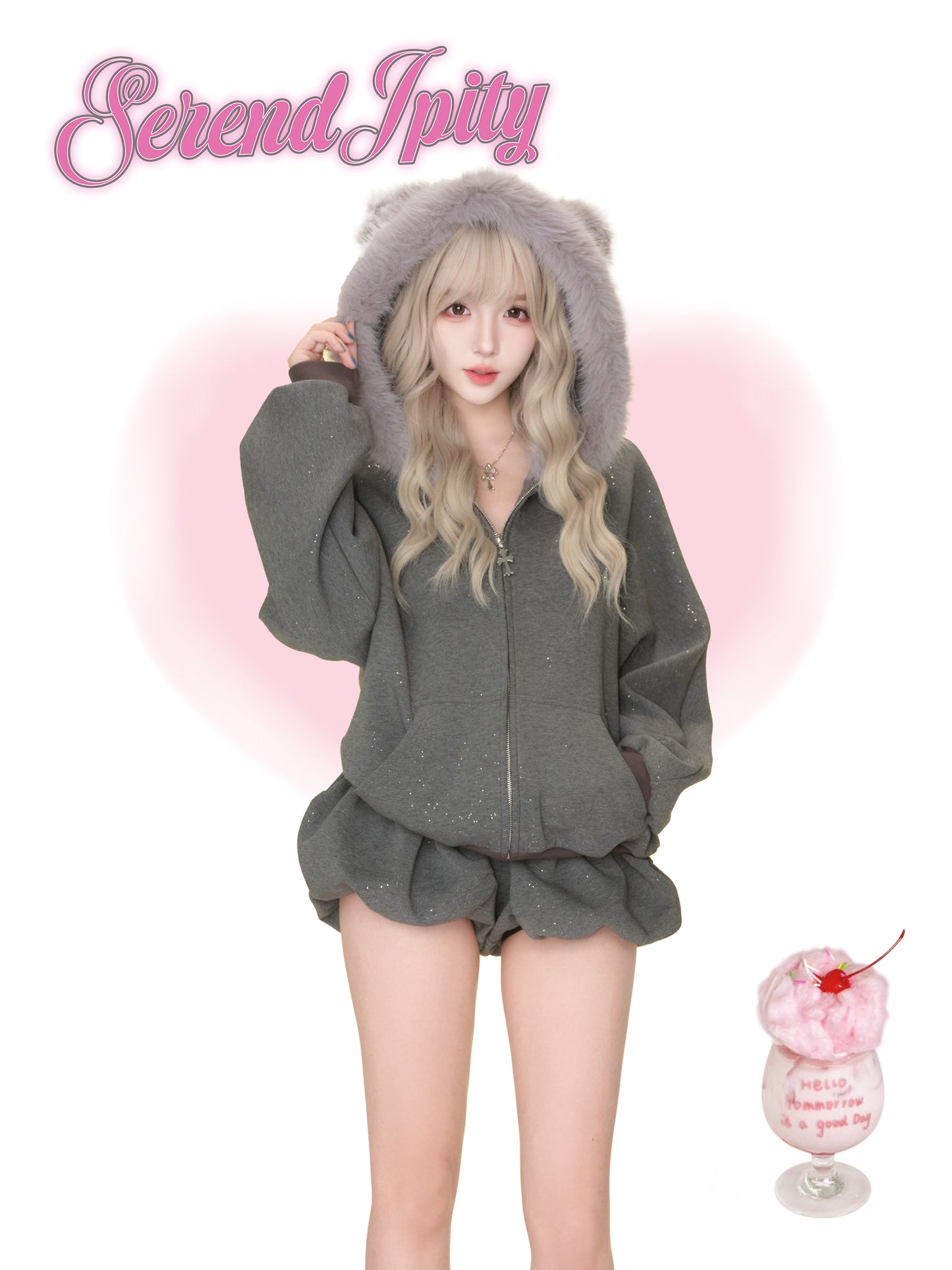 Person wearing a gray hoodie and shorts set with fluffy hood, standing against a white background with 'Serendipity' branding.