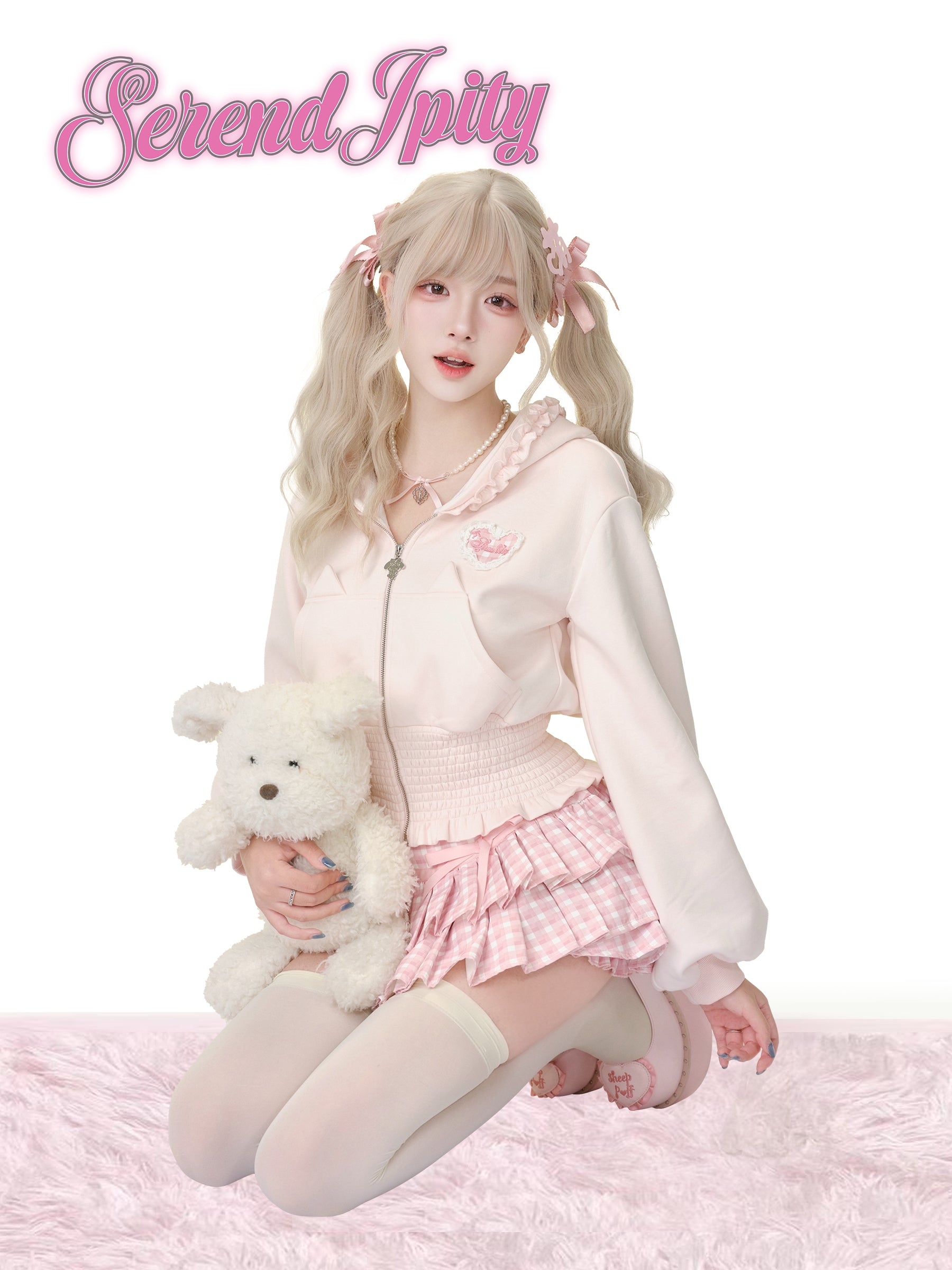 Person in a pink outfit holding a teddy bear with 'Serendipity' text above