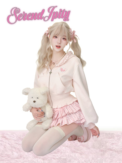 Person in a pink outfit holding a teddy bear with 'Serendipity' text above