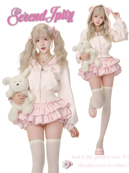 Two people in pastel outfits with teddy bears, wearing 'Serendipity' branded clothing.