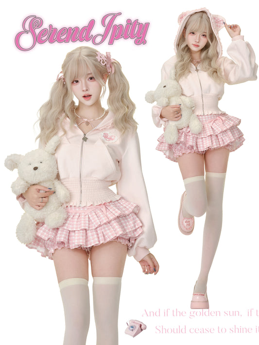 Two people in pastel outfits with teddy bears, wearing 'Serendipity' branded clothing.