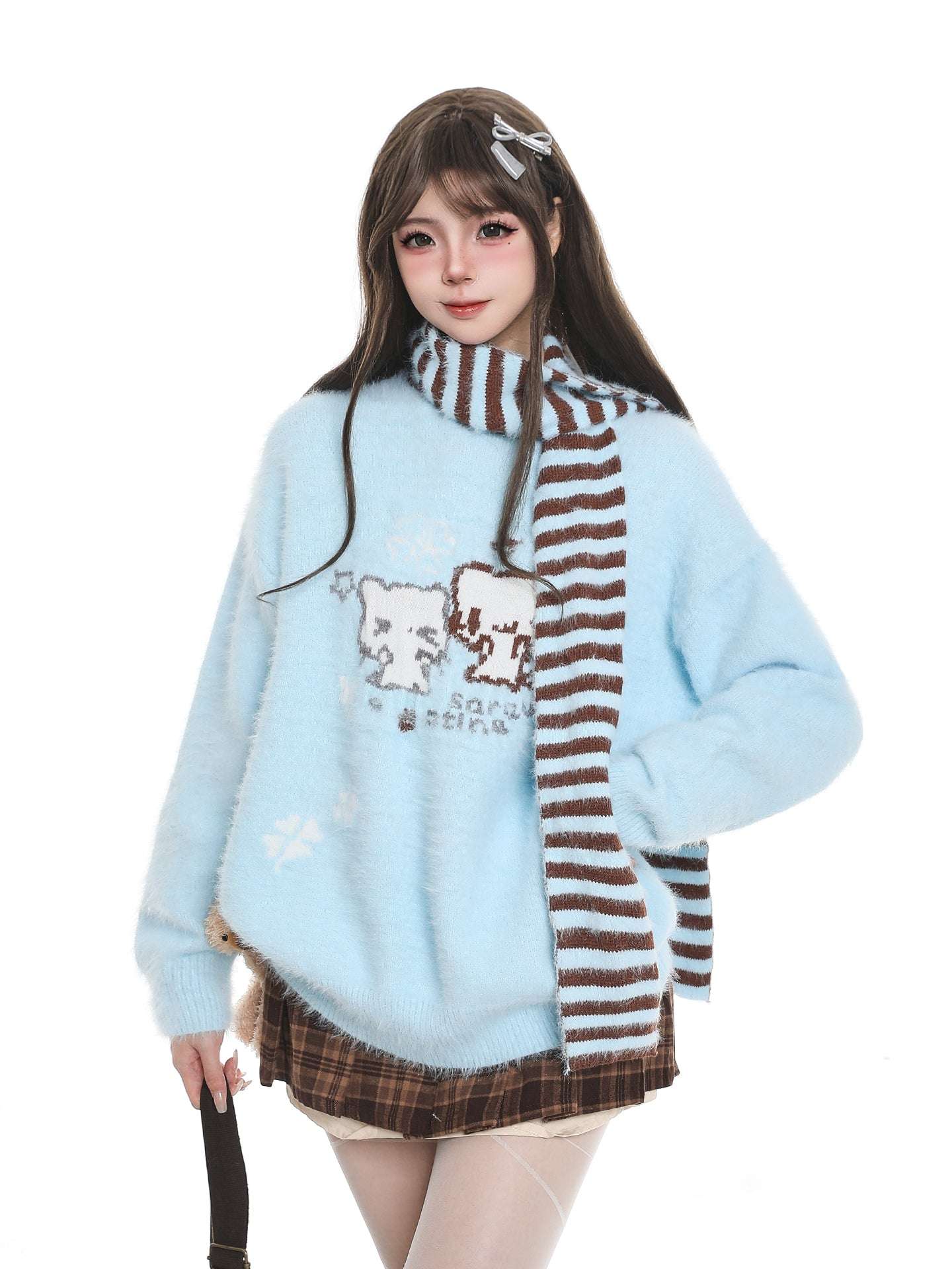 Woman wearing a light blue sweater with cat designs and a striped scarf on a white background