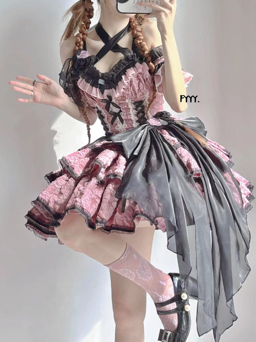 Person wearing a detailed pink and black dress with ruffles and a gray bow on a plain background.