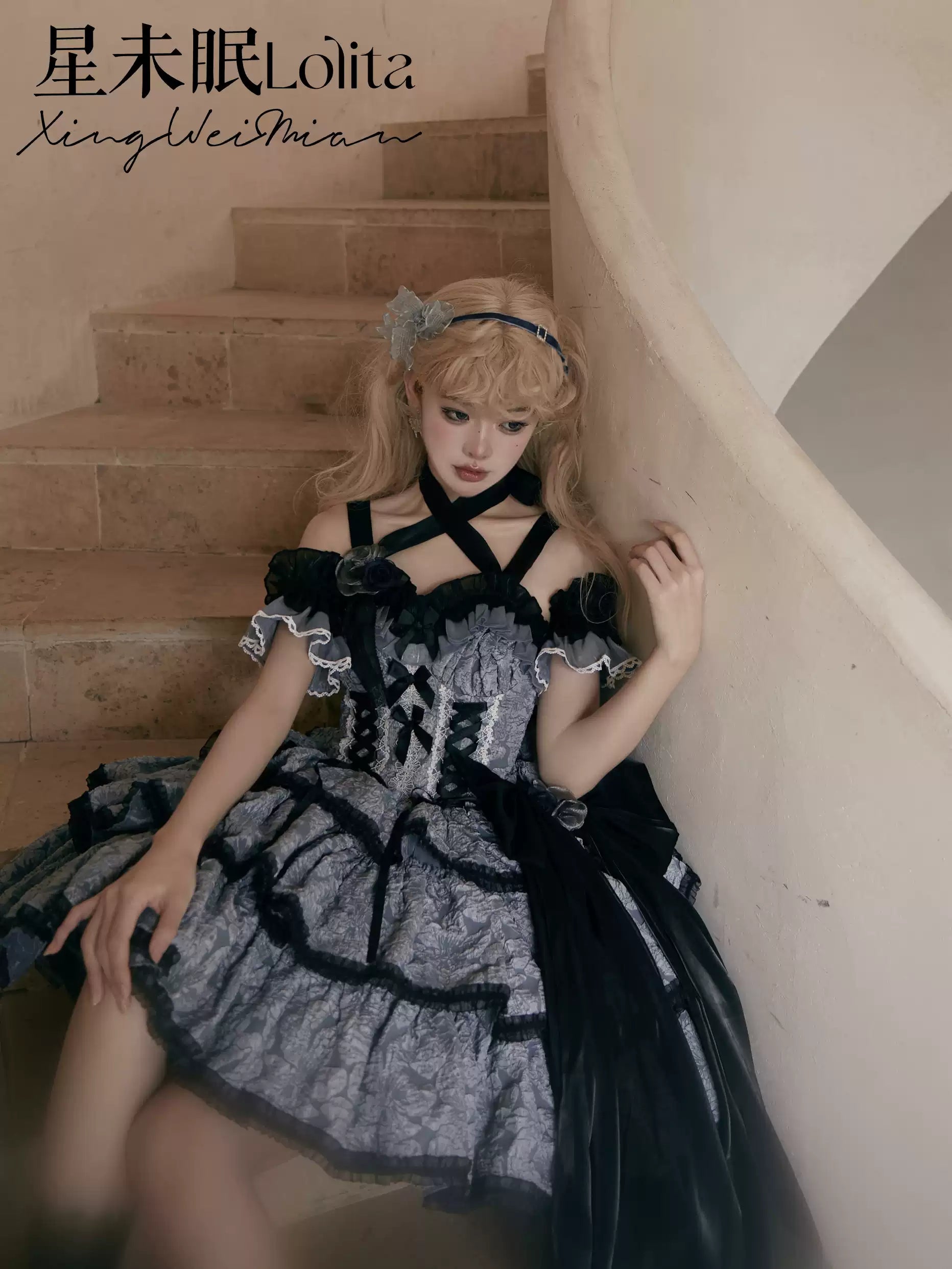 Person wearing a black and gray dress sitting on a staircase