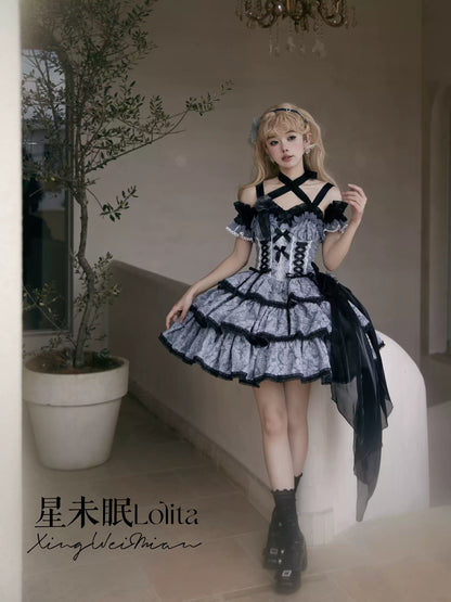 Person wearing a black and white Lolita dress in an indoor setting with a plant and chandelier.