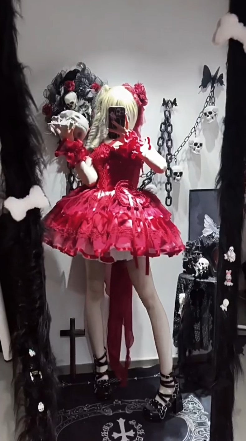 Person wearing a red dress with ruffles and black and white striped socks in a dark room.