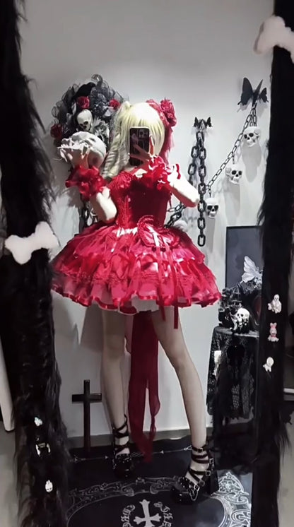 Person wearing a red dress with ruffles and black and white striped socks in a dark room.