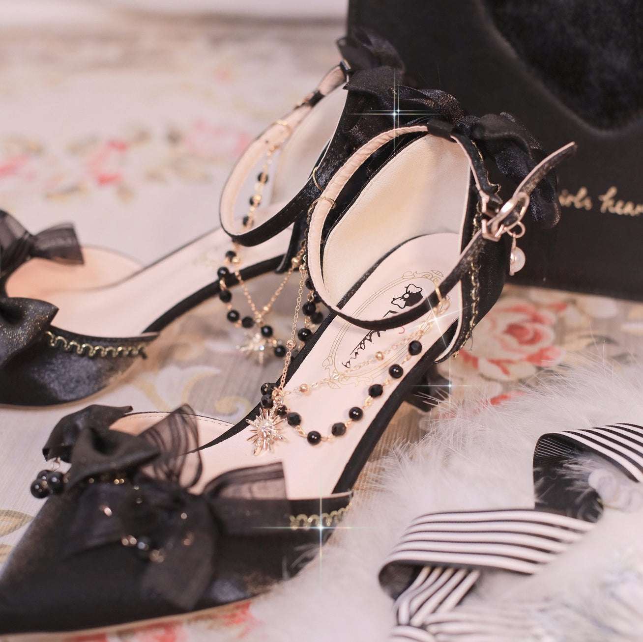 Black and white high-heeled shoes with decorative elements on a floral surface