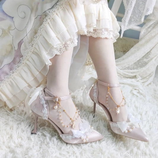 Delicate high-heeled shoes with lace and pearl details on a soft white background