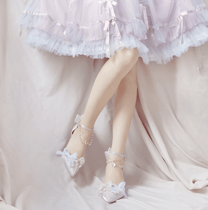 Pastel-colored dress with ruffled layers and white shoes with bows on a light background