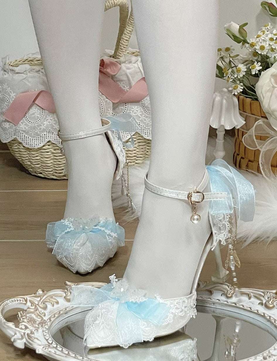 White high-heeled shoes with lace details on a decorative surface.