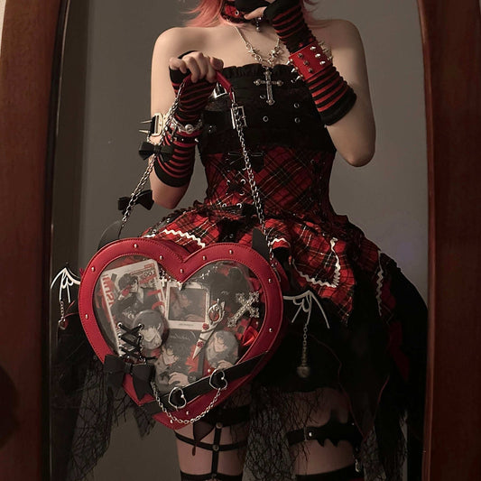 Person with pink hair and a unique outfit holding a heart-shaped bag.