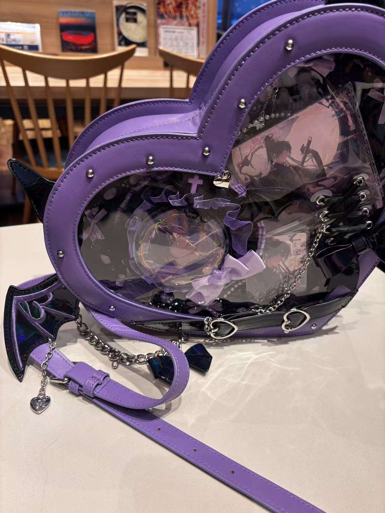 Purple heart-shaped bag with clear front on a table