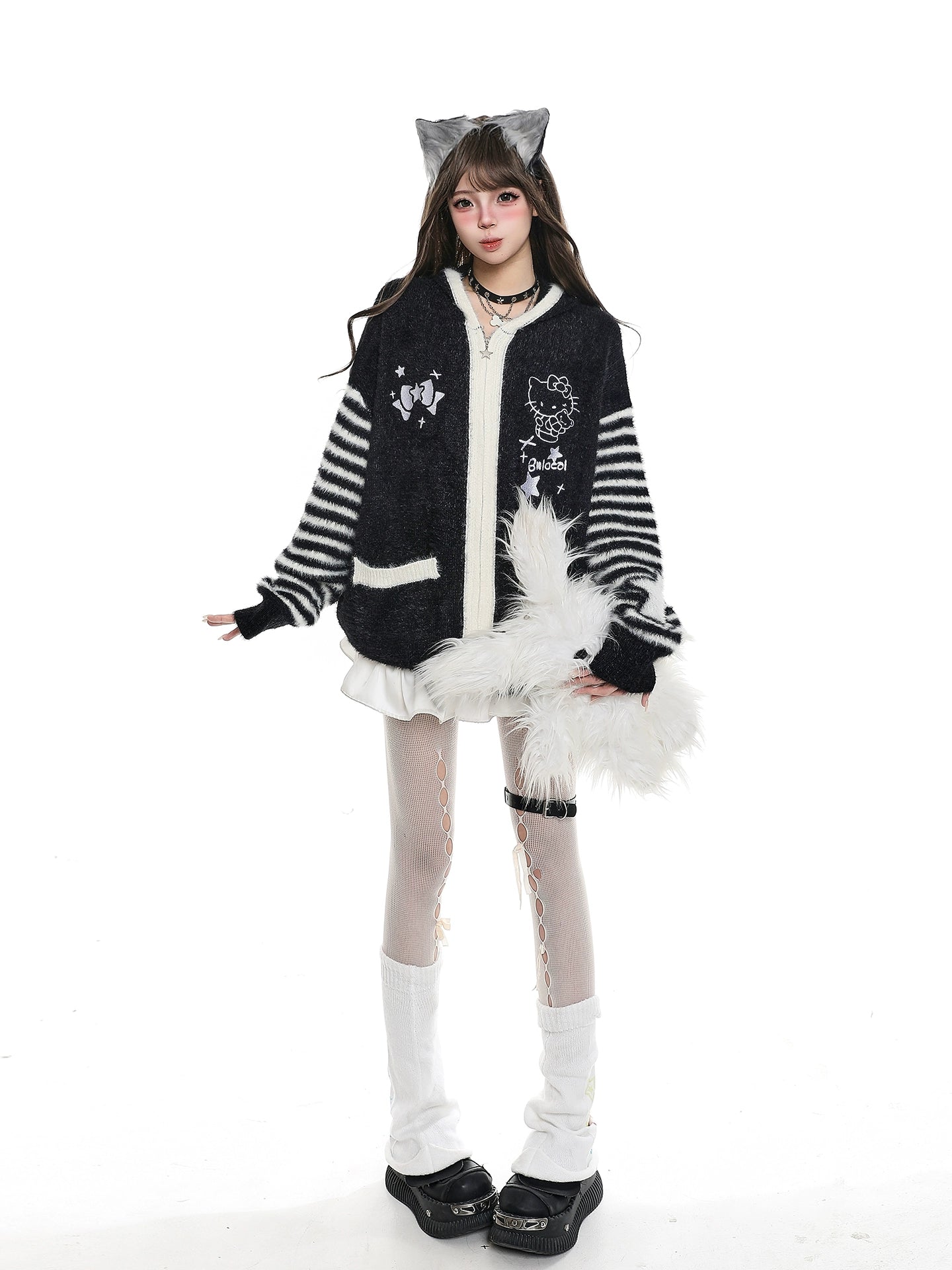 Person wearing a black and white costume with cat ears on a white background