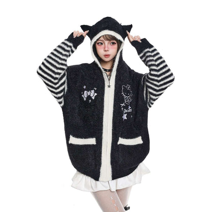 Person wearing a black and white striped hoodie with cartoon designs on a white background