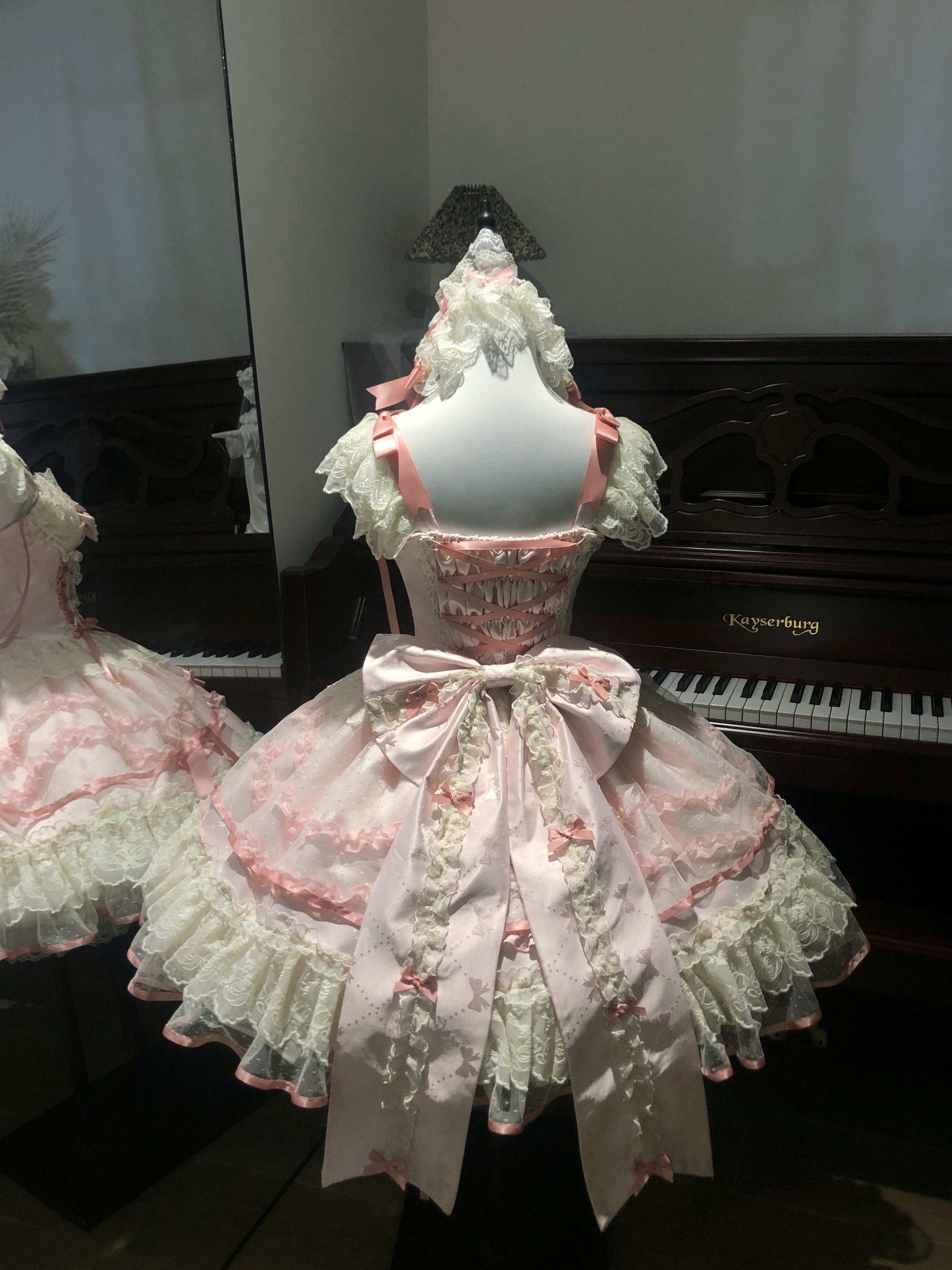 Pink Lace dress on a mannequin in front of a piano