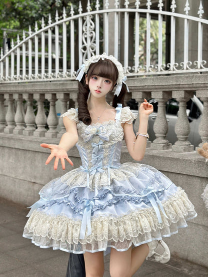 Person wearing a detailed blue dress with ruffles and lace in front of a decorative metal fence.