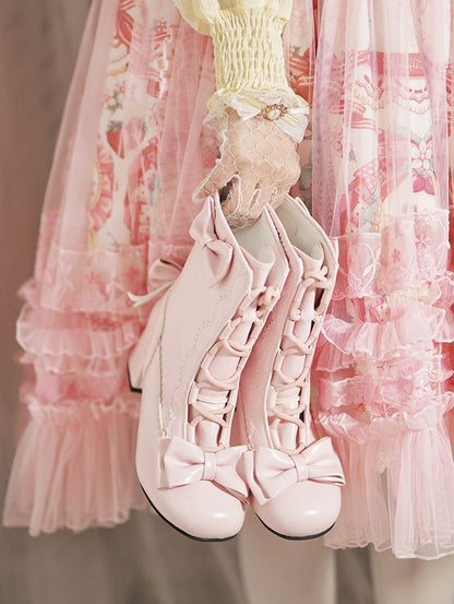 Pink high-heeled shoes with bows in front of a pink ruffled curtain