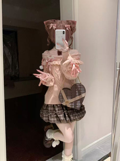 Person wearing a pink sweater and plaid skirt with a heart-shaped bag, taking a mirror selfie.