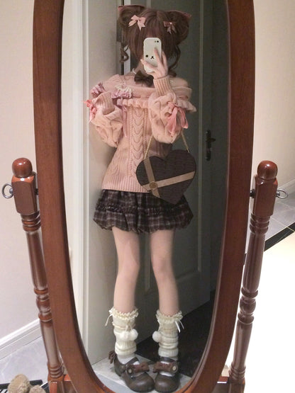 Person taking a mirror selfie wearing a pink sweater, plaid skirt, and white socks with brown shoes.