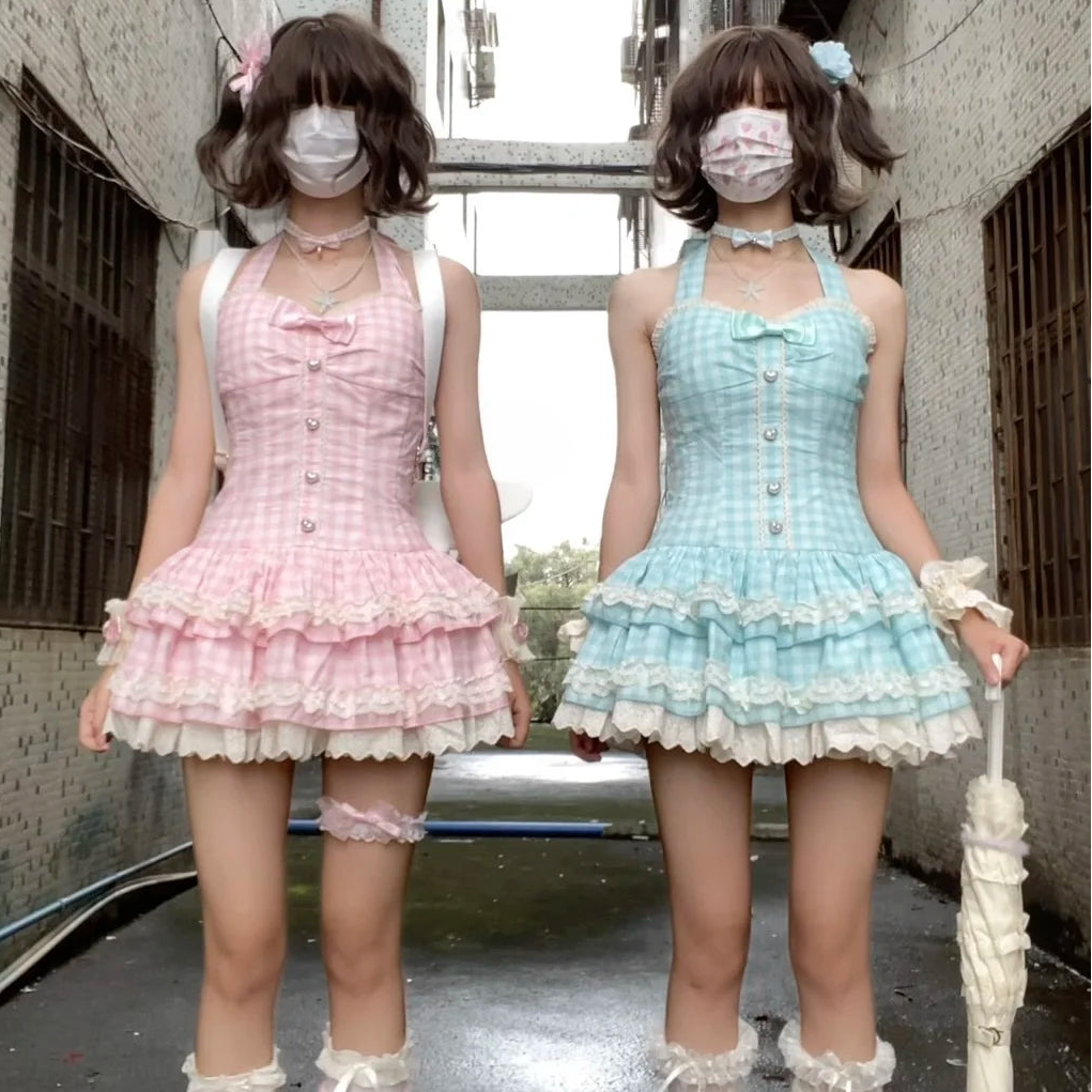 Two women in pastel dresses and high-heeled shoes standing in an urban setting.