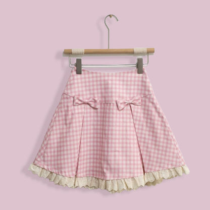 Pink gingham skirt with ruffle hem on a hanger against a pink background