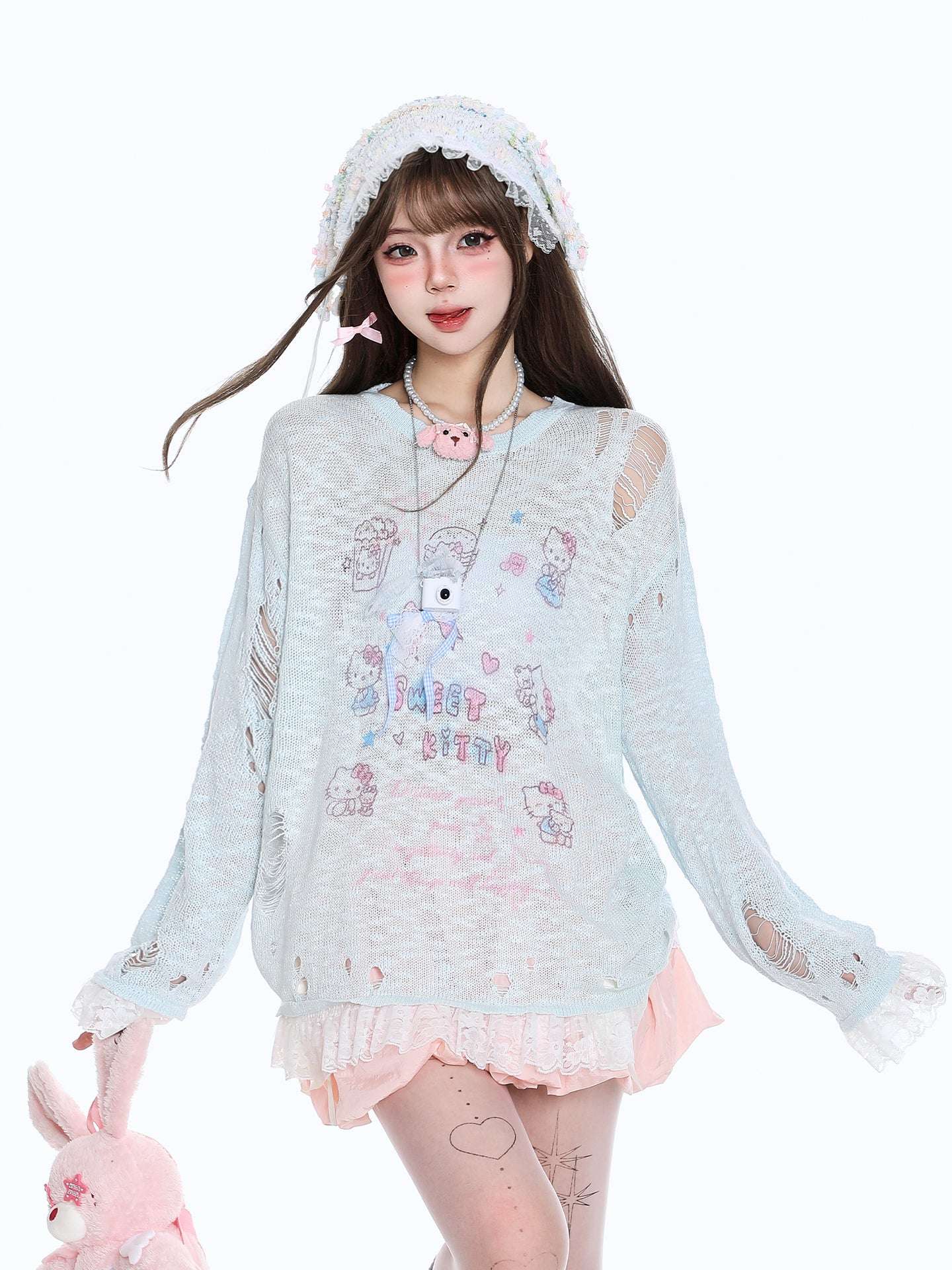 Person wearing a light blue sweater with cartoon designs on a white background