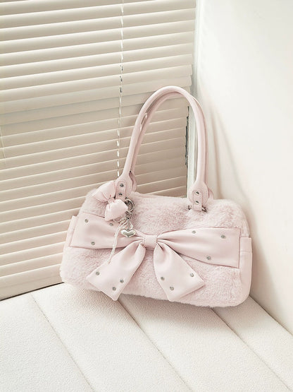 Pink handbag with a large bow on a white surface