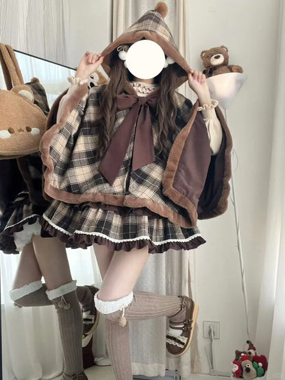 Person wearing a brown plaid outfit with a large bow and hood, surrounded by plush toys.