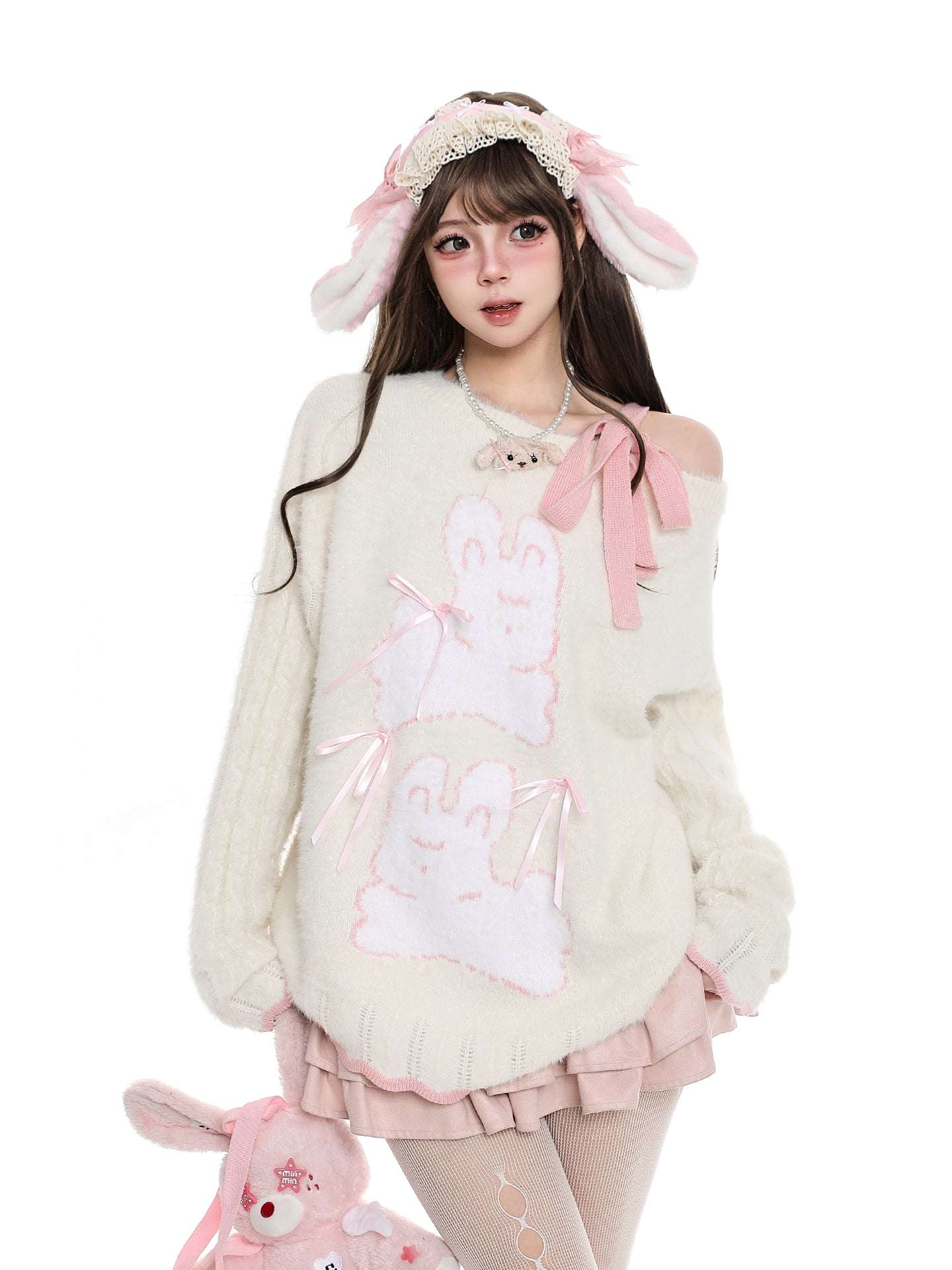 Person wearing a cute outfit with bunny ears and a white sweater on a white background