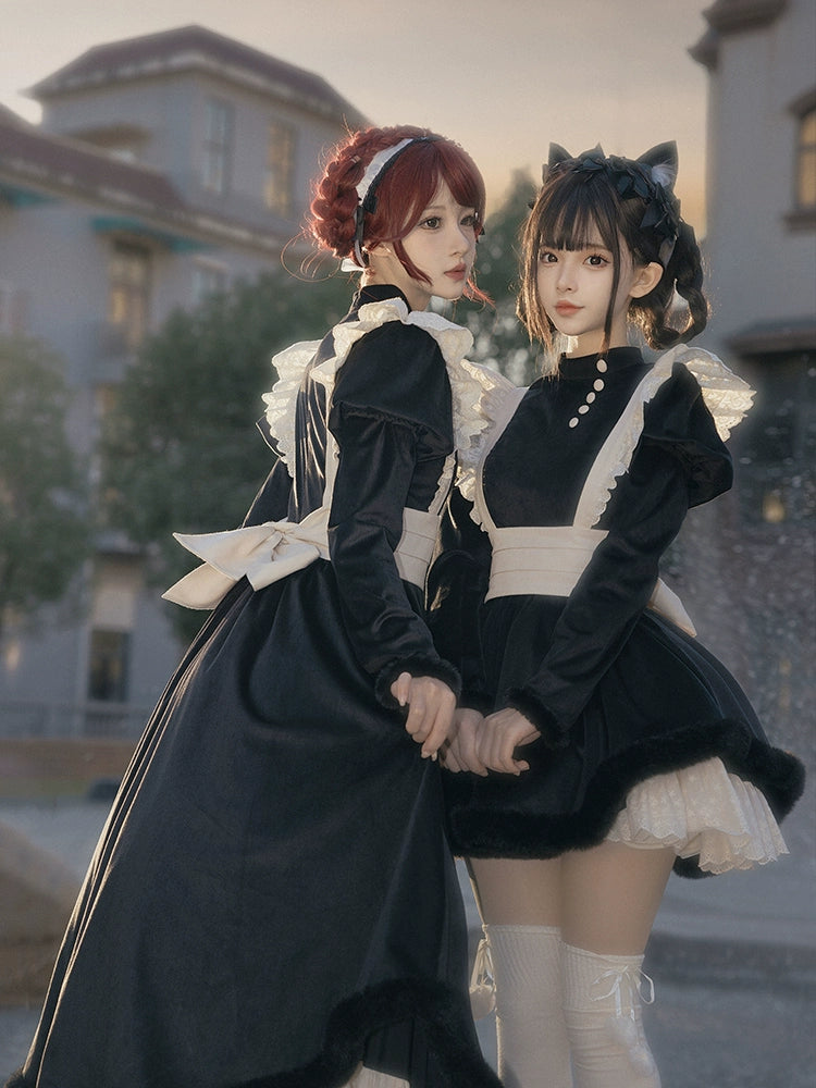 Two people in black and white maid outfits standing together outdoors.