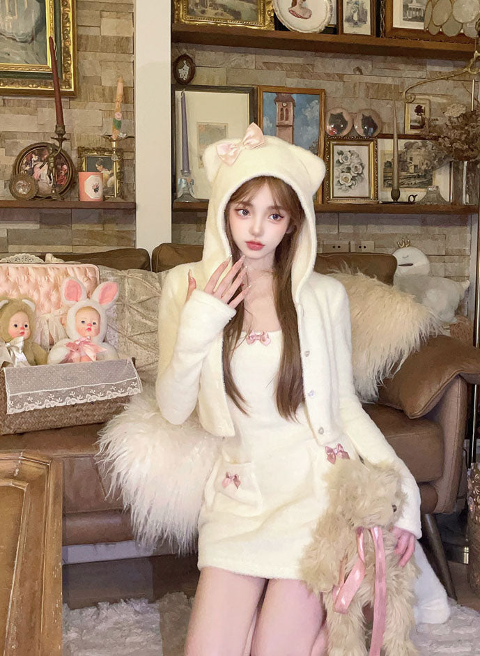 Person wearing a white fluffy outfit with bear ears in a cozy living room.