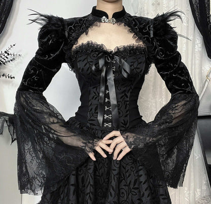 Black lace dress with long sleeves and intricate detailing on a neutral background