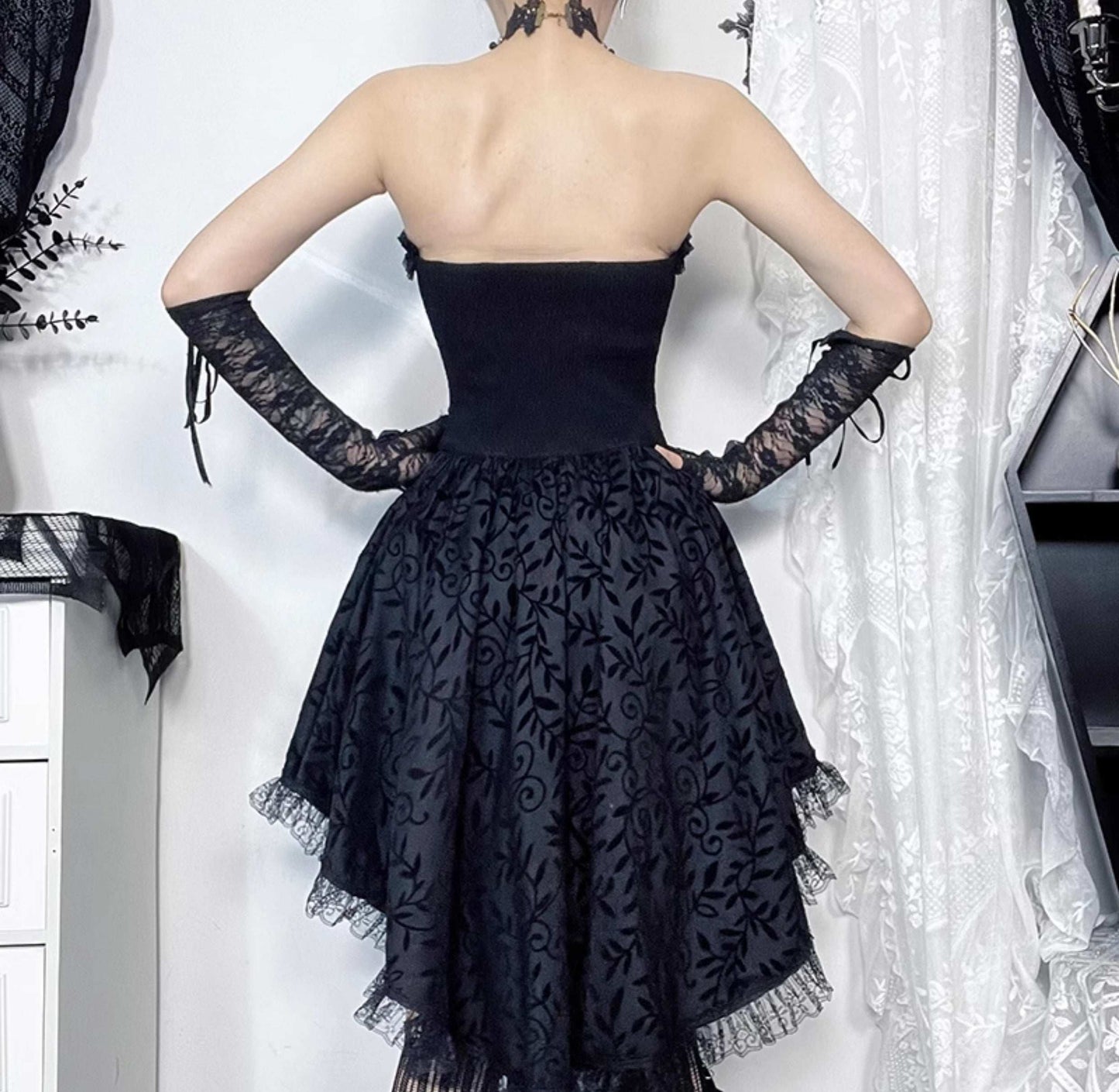 Black lace dress with sheer sleeves on a white background