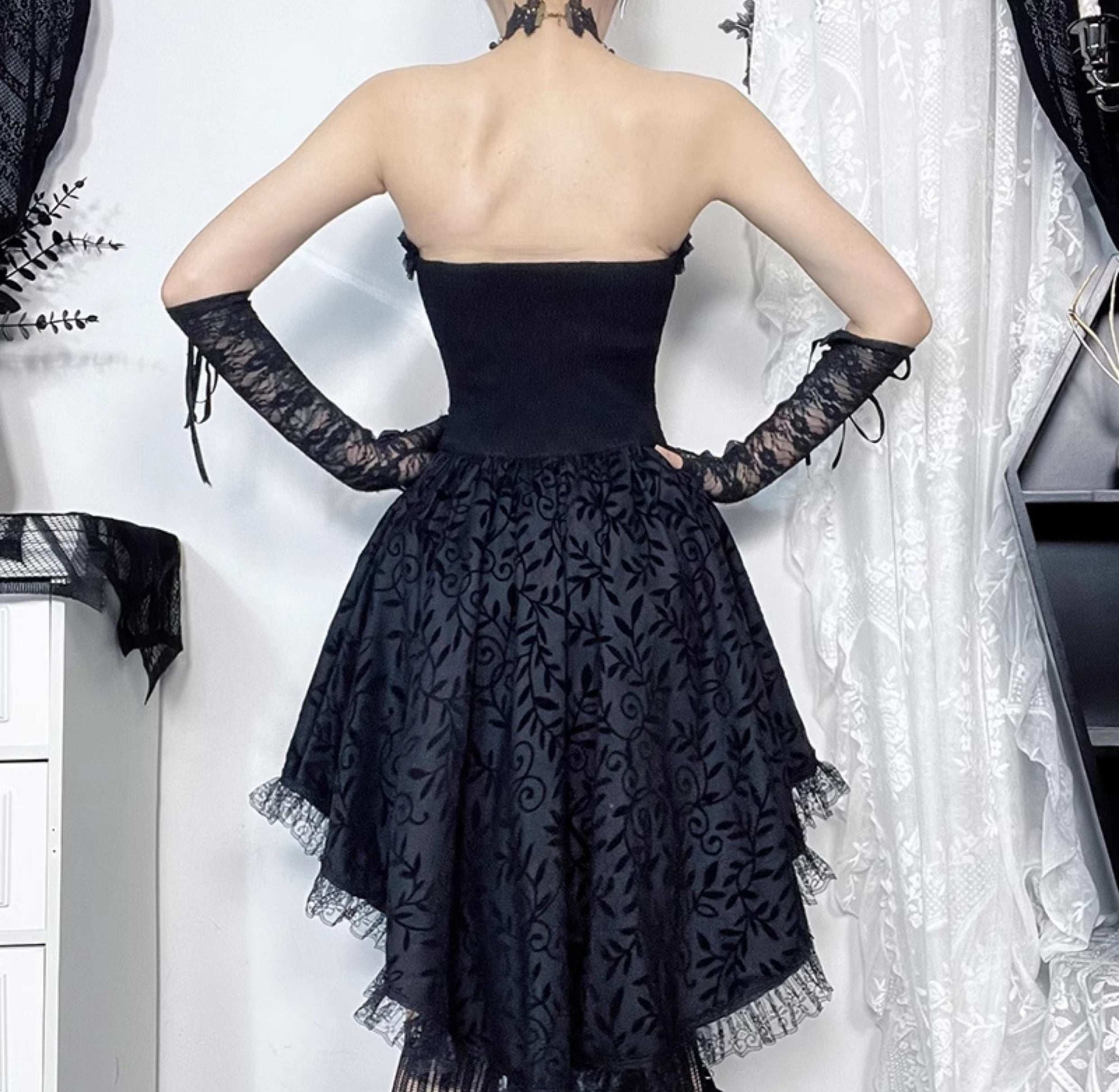 Black lace dress with sheer sleeves on a white background