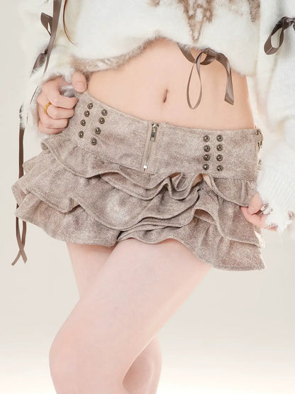 Person wearing a layered skirt with buttons and zippers on a light background