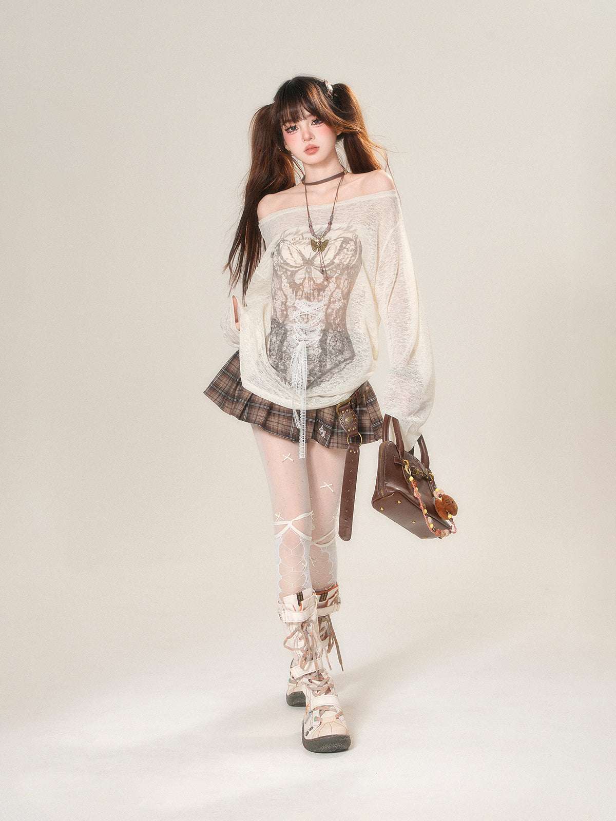 Woman wearing a white off-shoulder top, plaid skirt, and high-heeled boots on a plain background