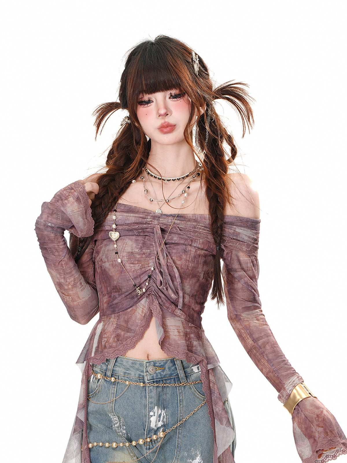 Person wearing a stylish outfit with a sheer top and denim skirt on a white background