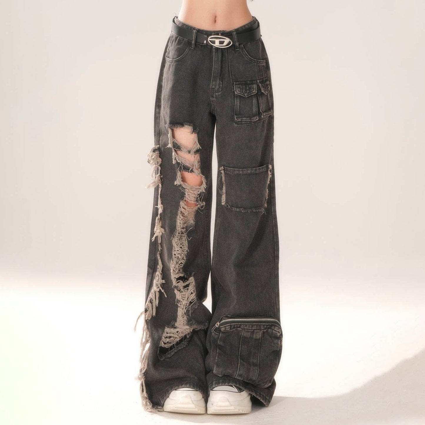 Distressed black jeans with a belt on a white background